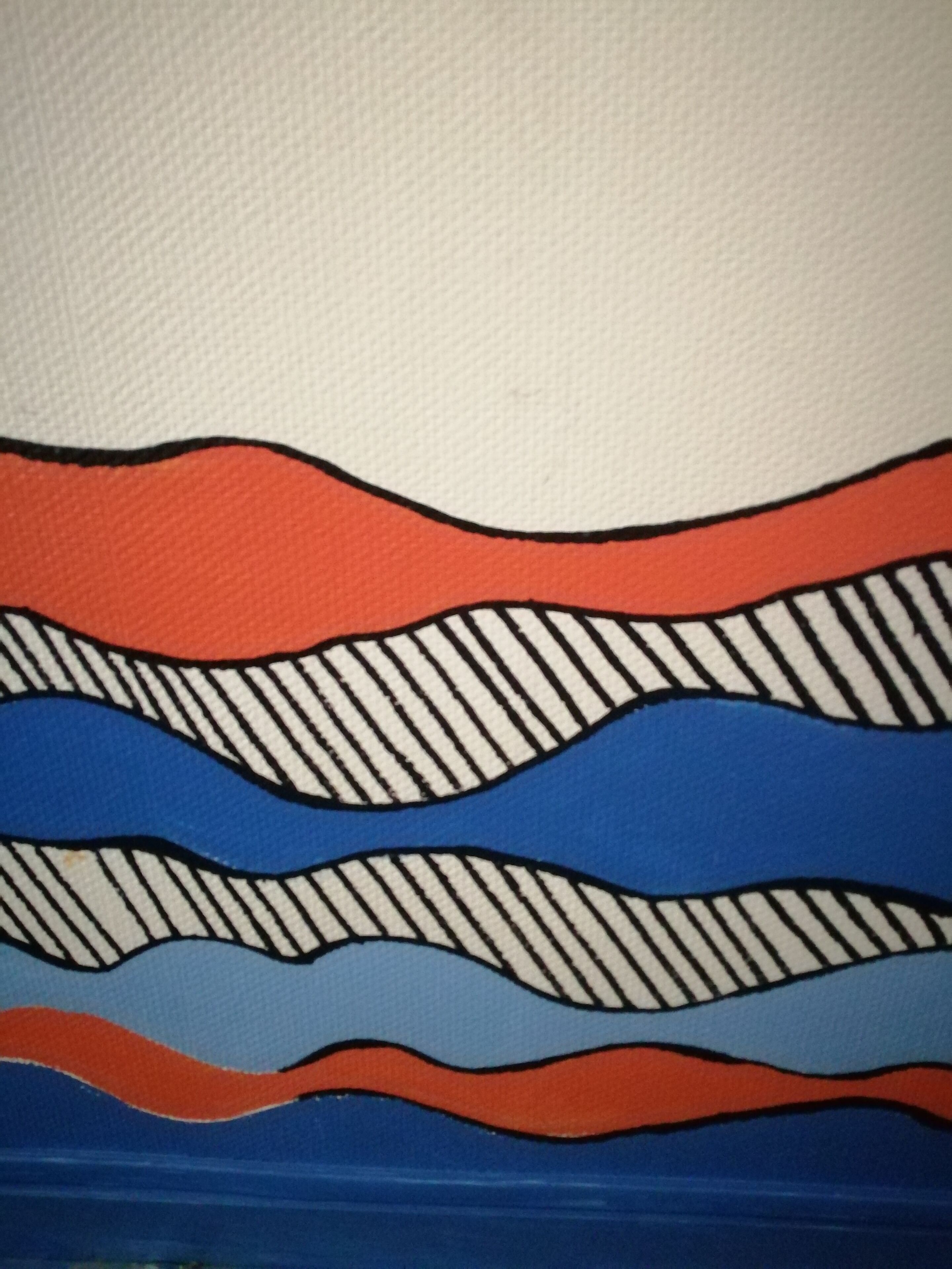 Un mur à la texture particulière, orné d’un motif à plusieurs couches de lignes ondulées dans les tons rouge, bleu et blanc.