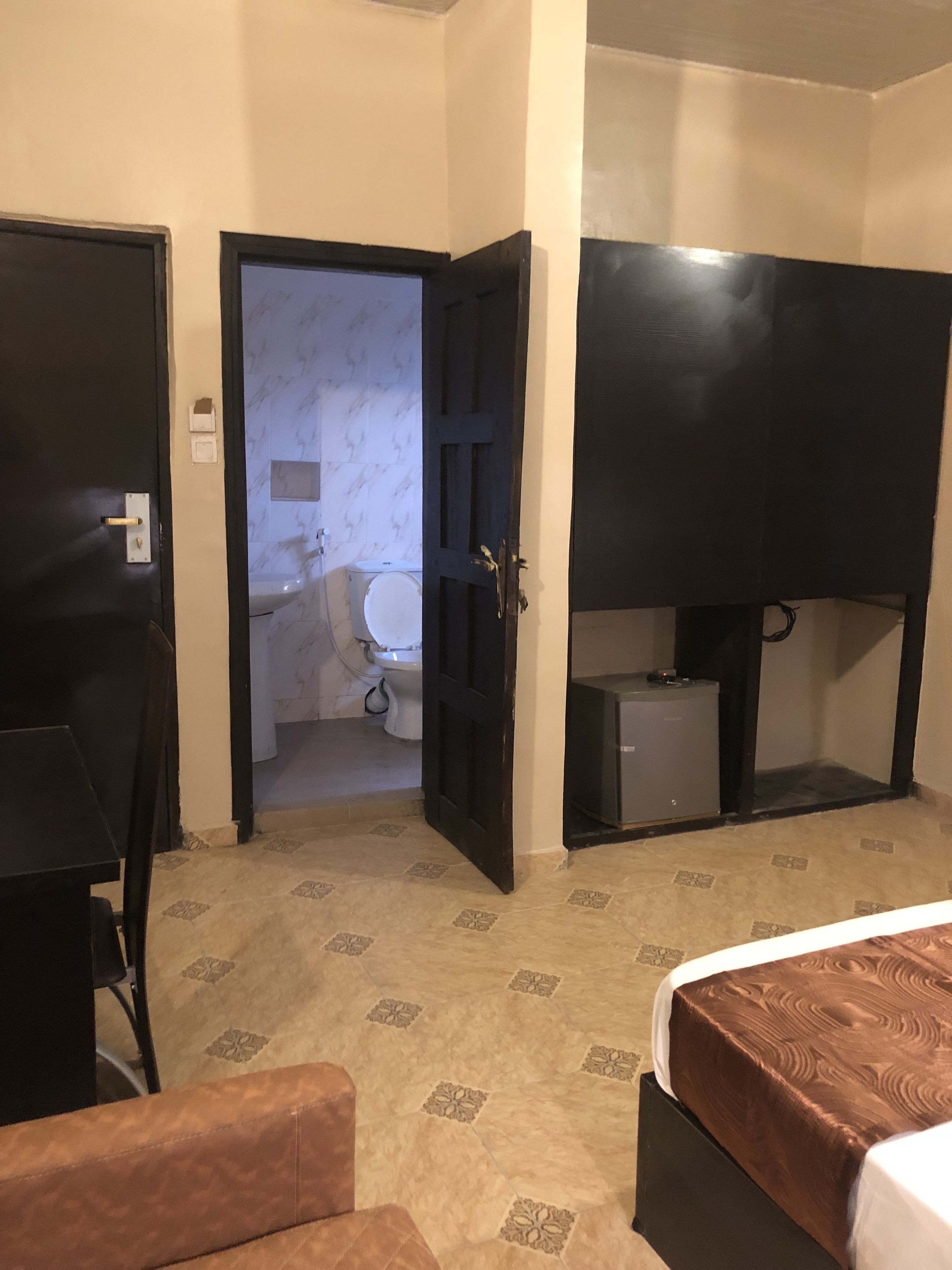 Una habitación de hotel con una cama, un escritorio, una silla y un televisor.
