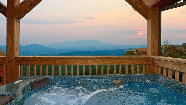 A hot tub with a wooden deck and a view of mountains. - 🌙 Midnight Wonder 🏔️ Twinkling Valley Lights, Hot Tub & Resort Pool (Sevierville)
