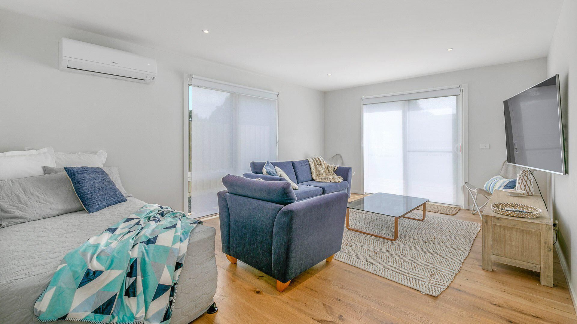 A modern living room with a sofa, a coffee table, and a TV.