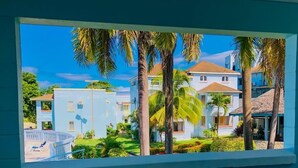 A view of a residential area with houses, palm trees, and a clear blue sky. - Heaven-Can-Wait @ Point Village (Negril)