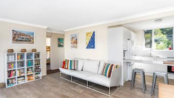 Relax in this inviting space with a sofa, bookshelf, and desk area.