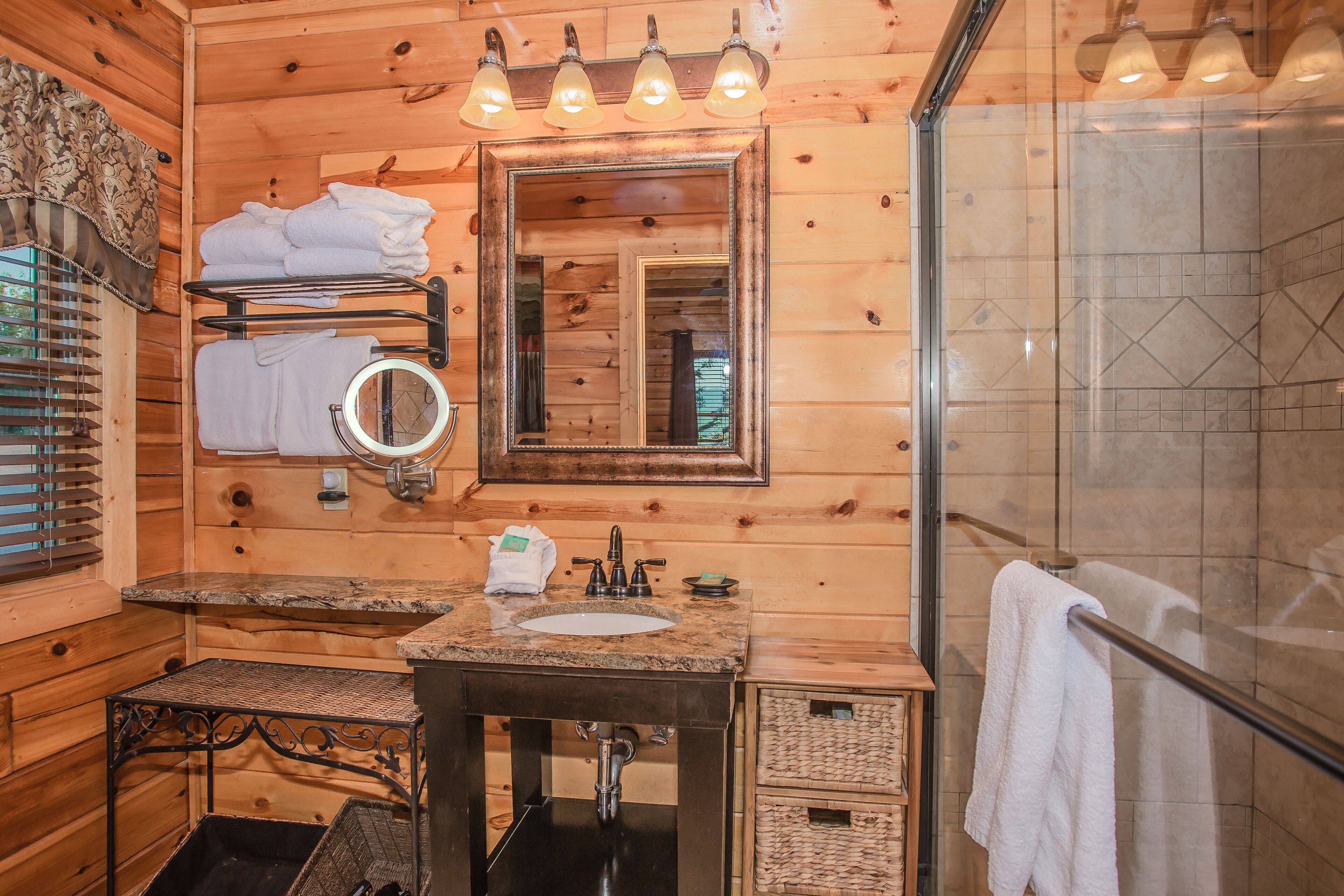 Ein Badezimmer einer Holzhütte mit Waschbecken, Spiegel und Handtuchhalter.