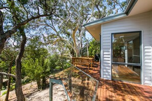 A modern house with a deck, large windows, and a view of trees. - Alto Vista (Lorne)