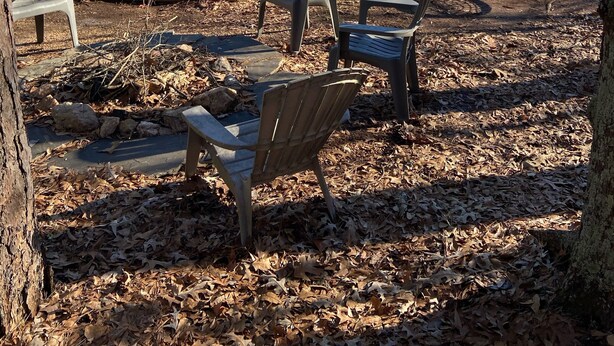 Een steiger aan het meer met een afdekkleed, stoelen en een schommelstoel.