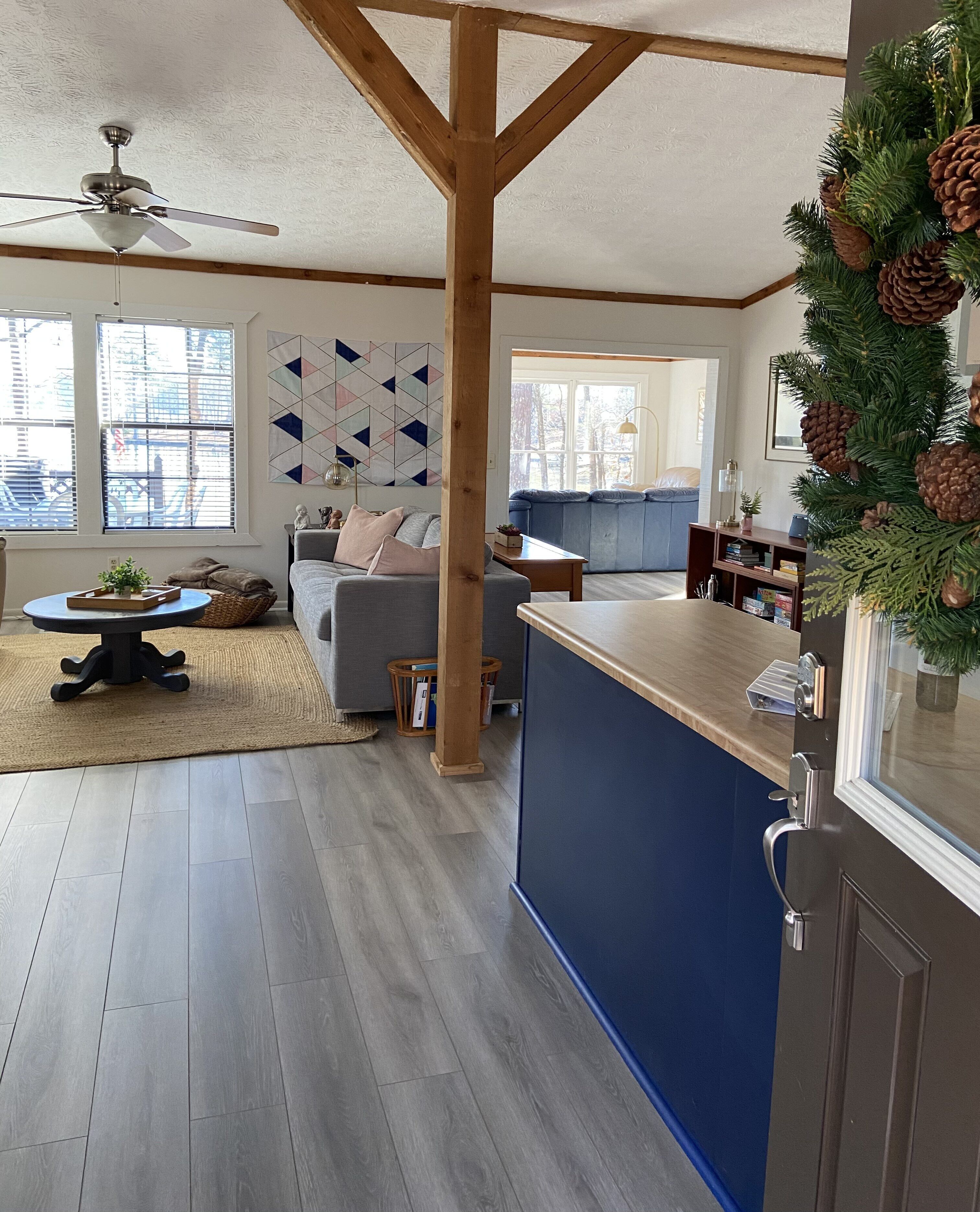 Una cocina moderna con encimera azul, vigas de madera y un ventilador de techo.