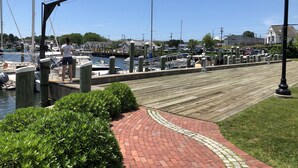 A marina with boats docked, a wooden walkway, and a clear blue sky. - Walk to beaches & ferries ★ Snow's Creek Waterview (Barnstable)