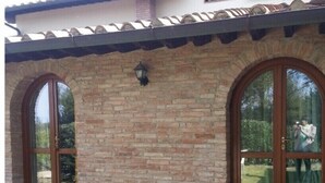 A two-story house with a brick facade, large arched windows, and a tiled roof. - POOL FARM - APARTMENT 4 PERSONS - 2 BEDROOMS 2 BATHROOMS  (La Serra)