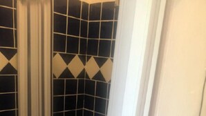 A bathroom with black and white checkered tiles, a shower enclosure, and a toilet. - Holiday house in Palinuro center (Palinuro)