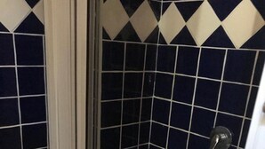 A bathroom with a shower area, a toilet, and a tiled floor. - Holiday house in Palinuro center (Palinuro)