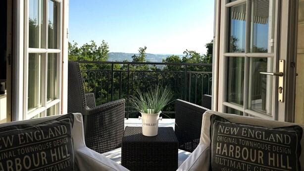 An open balcony with a view of the countryside, wicker furniture, and a potted plant. - Rocaille, villa with private pool, views, privacy, comfort and service (Pujols)