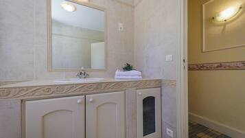 A bathroom with a sink, mirror, decorative molding, and a towel rack.