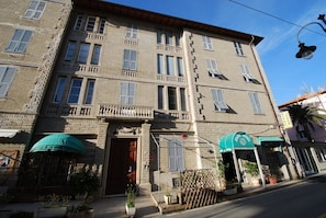 A multi-story building with a traditional facade, featuring a central entrance with a wooden door, balconies, and a green awning. - Apartment Sea Breeze Deiva Marina 4 Tinetto (Deiva Marina)