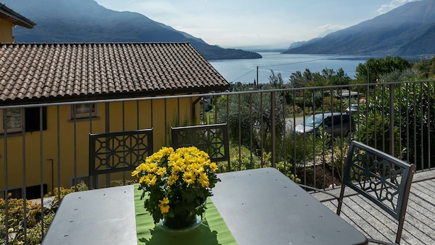 A yellow building with a tiled roof overlooking a lake and mountains. - Lake Como - Residence La Collina - Orange (Vercana)