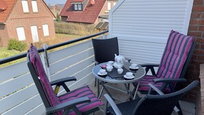 Ein Balkon mit zwei Stühlen, einem Tisch und einem Tee-Service.