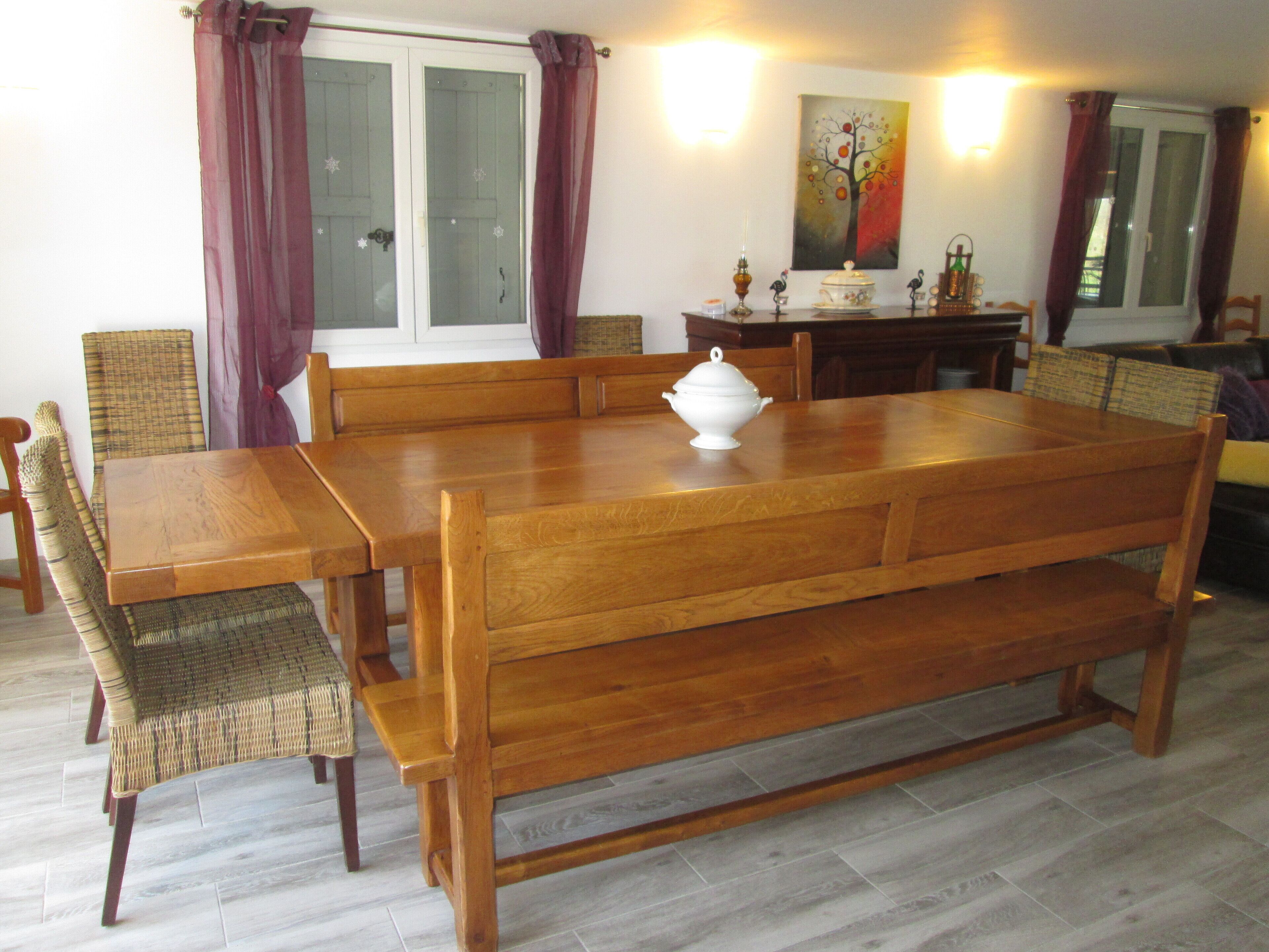 Un coin repas avec une table et des chaises en bois, une lampe décorative et un tableau au mur.
