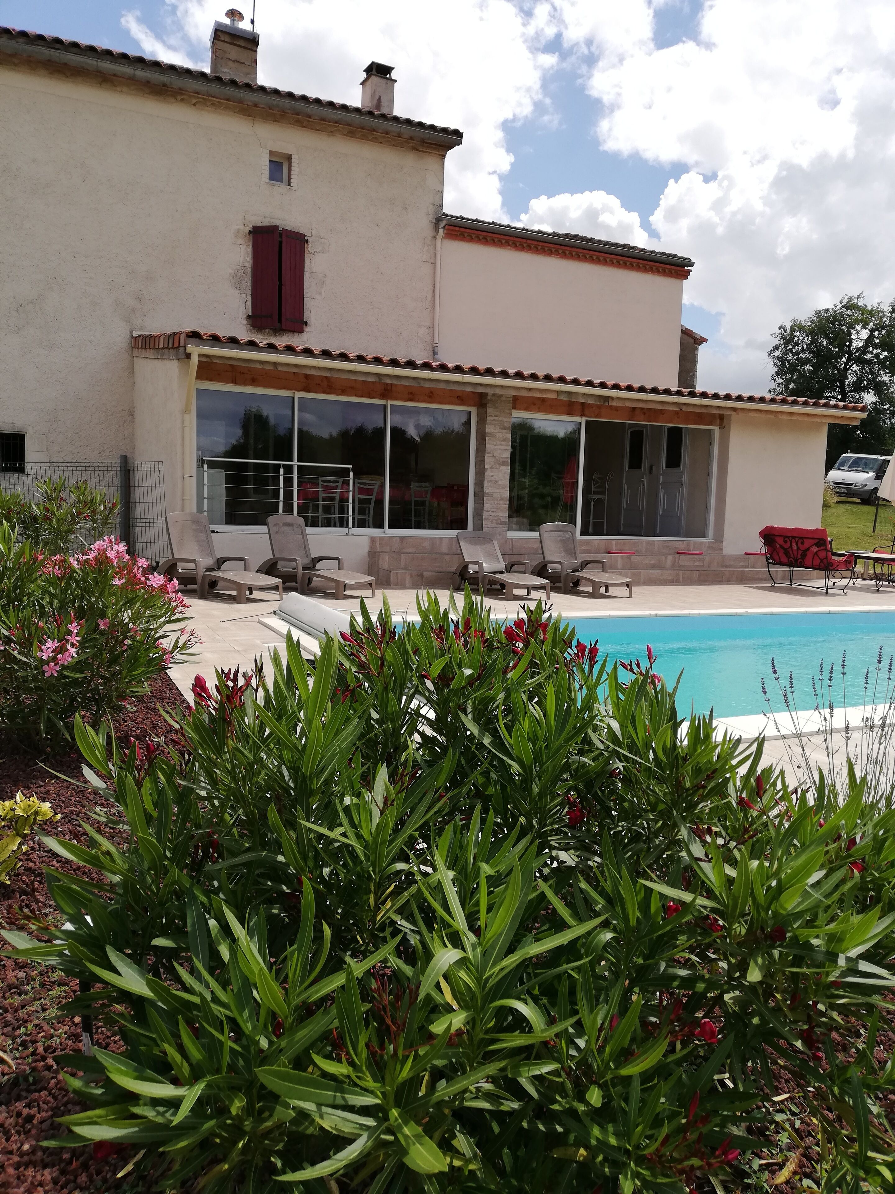 Une maison avec une piscine, un espace extérieur aménagé et un jardin.