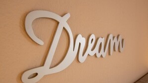 A wall with a white, cursive, three-dimensional word "Dream" in a decorative style. - Vacation apartment Meerestraum (Norddeich)