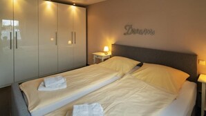 A hotel room with a double bed, two bedside tables, a wardrobe, and a wall-mounted sign that reads "Dream." - Vacation apartment Meerestraum (Norddeich)