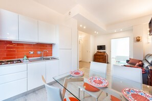 Enjoy a meal at the glass dining table, surrounded by a comfortable sofa and flat-screen TV.