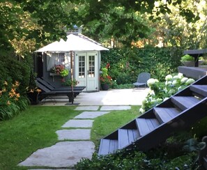 Escape to a serene garden oasis with a charming gazebo surrounded by lush greenery and a meandering stone pathway.