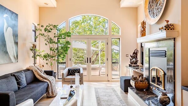 A spacious living room with a fireplace, a large window, and a view of the outdoors. - Resort-like Villa, 50' Infinity Edge Pool, Garden, Peaceful, Luxurious (Sonoma)