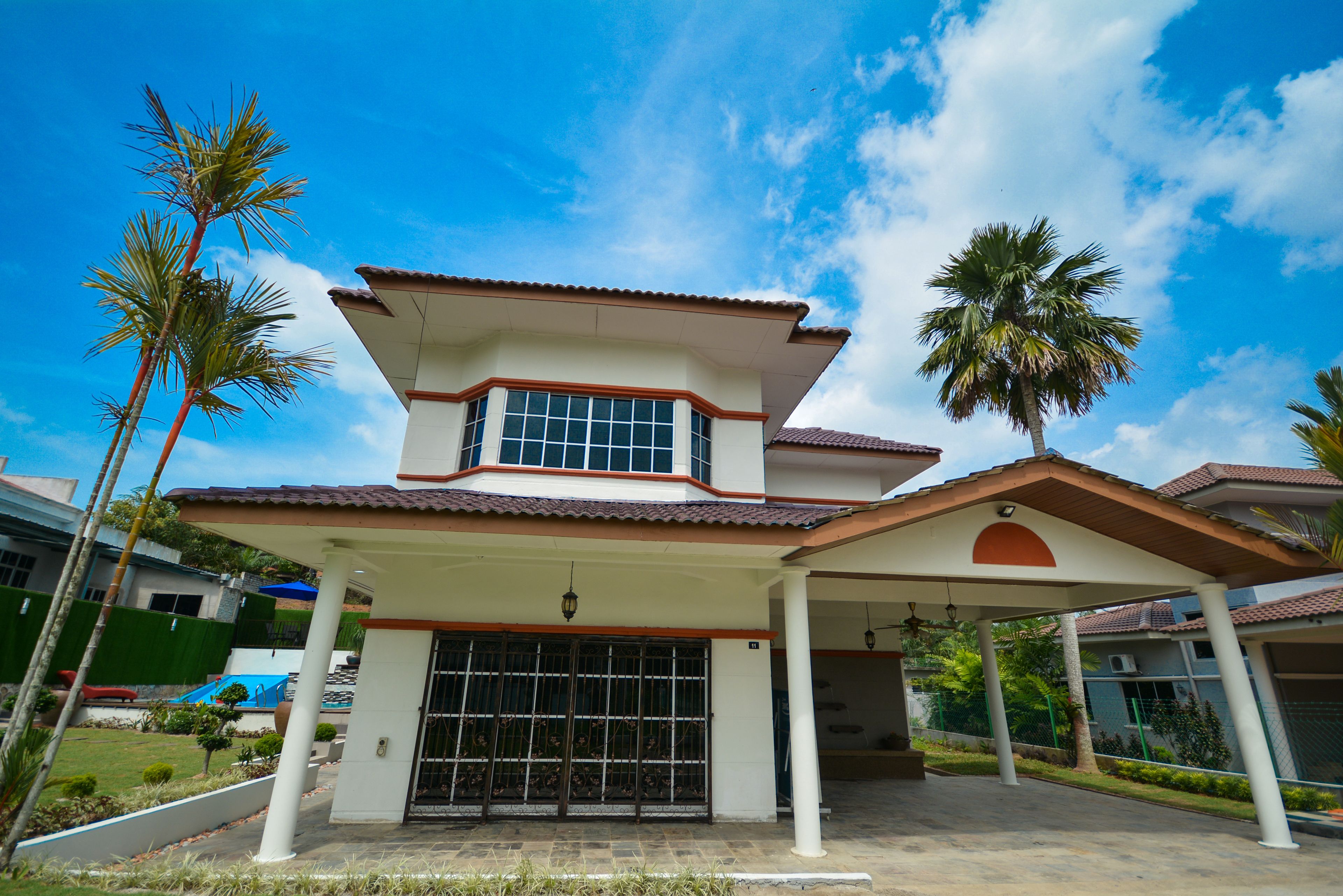 A two-story house with a covered patio, a garage, and a fenced yard.