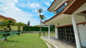 Um imóvel residencial com alpendre, quintal cercado e muro de pedra.