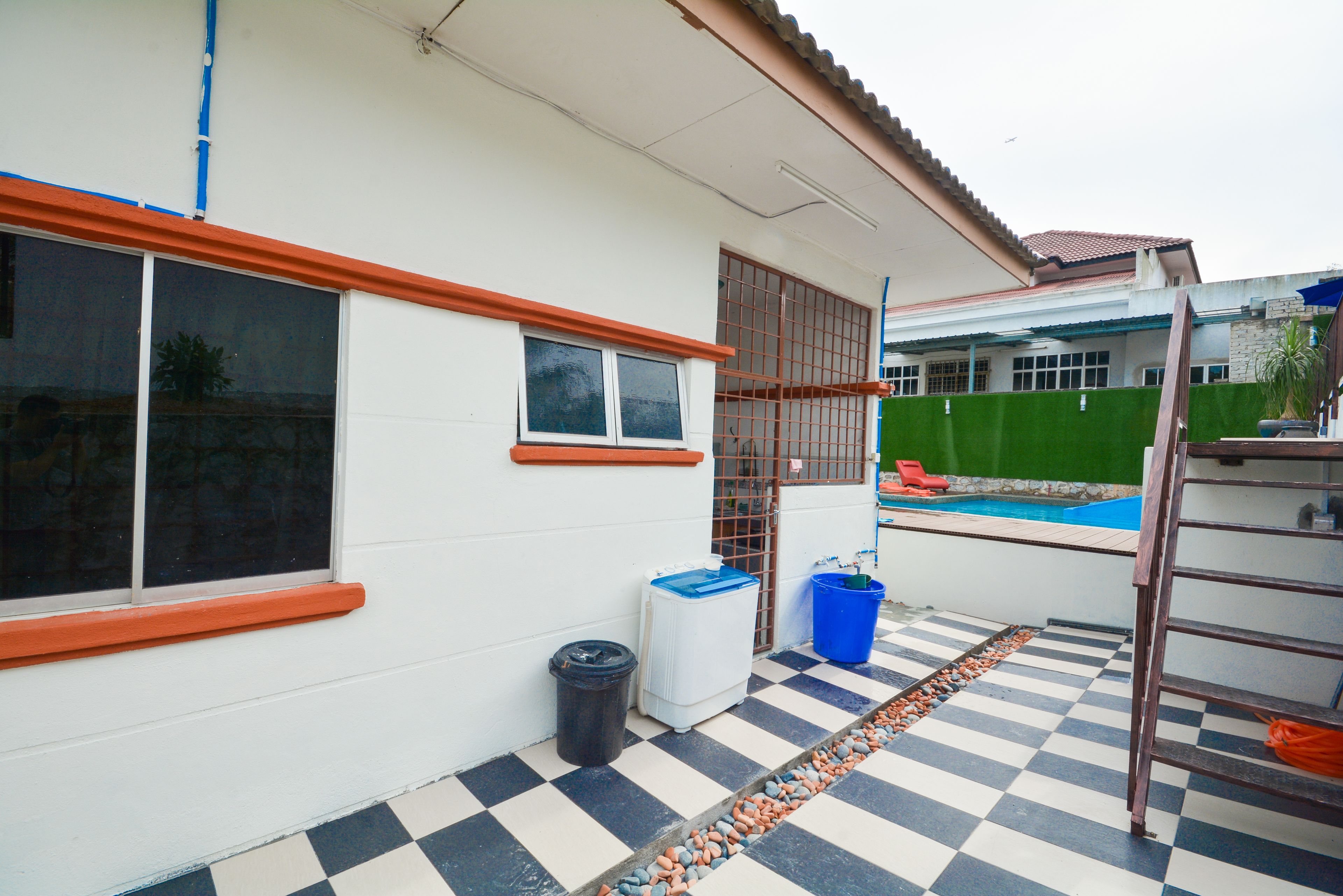 A house with a checkered floor, a swimming pool, and a ladder.