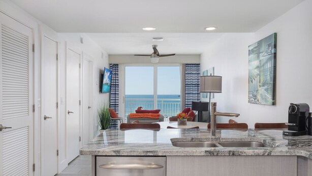 Una cocina moderna con una isla grande, un lavamanos integrado y vistas al mar.