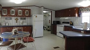 Eine kompakte Küche mit Essbereich, Kühlschrank, Mikrowelle und Herd.