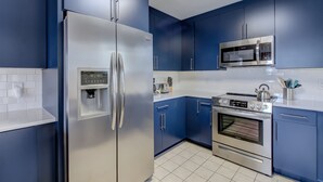 A modern kitchen with stainless steel appliances, blue cabinets, and white countertops. - Heated Private Pool - Bring your Kayak  (Savannah)