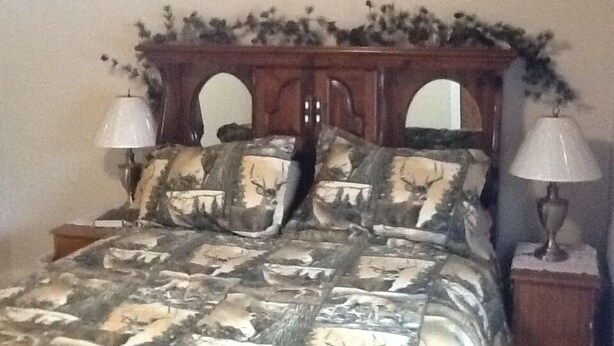 A bed with a headboard decorated with foliage and a sign that reads "Weekend Getaway". - 3 Bedroom, Cozy Cottage Near Seney Wildlife Refuge (Seney)