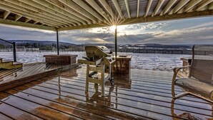 A covered outdoor area with a wooden deck, a grill, and a view of a snowy landscape. - Nunda Ranch near Letchworth State Park (Nunda)