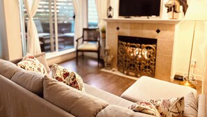 A living room with a sofa, a fireplace, and a television.