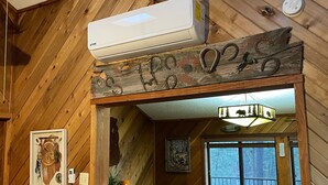 A wooden interior with a dining area, a ceiling fan, and a rustic decor. - Cozy, Rustic Pine Ridge Cabin with beautiful views - Midtown Ruidoso (Ruidoso)