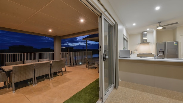 Une terrasse extérieure avec un ensemble de mobilier de jardin et une vue sur le ciel du soir.