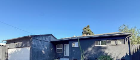 Ein zweistöckiges Haus mit Garage, Veranda und gepflegtem Rasen.