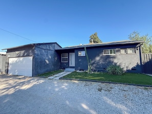 A two-story house with a garage, a front porch, and a well-maintained lawn.