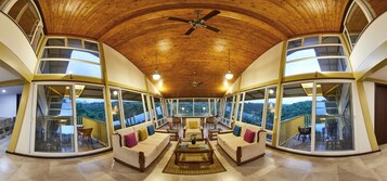 Amplia sala de estar con techo alto y ventanas grandes que ofrecen vistas al exterior.