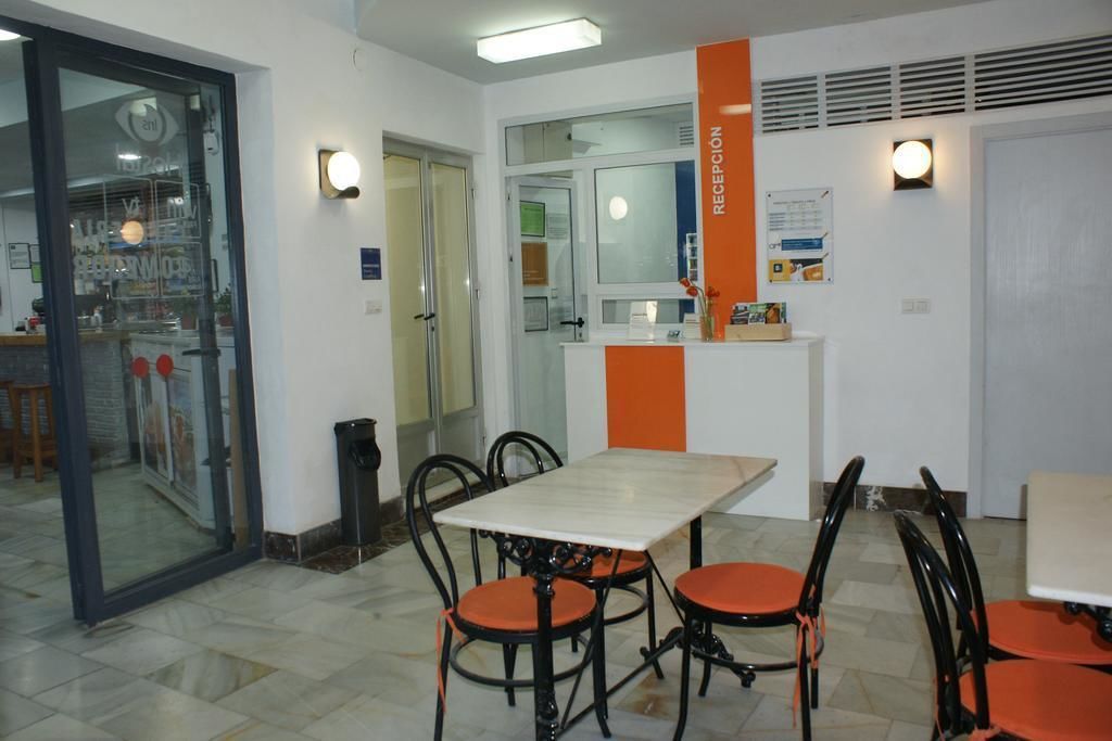 A reception area with a reception desk, chairs, and a glass door leading to another room.