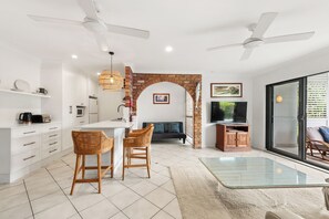 Relax in a spacious living area with a central island, flat-screen TV, and comfortable seating.