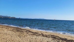 A beach with a clear sky, calm sea, and distant landforms. - Apartment in Cavalaire-sur-Mer near Beach (Cavalaire sur Mer)