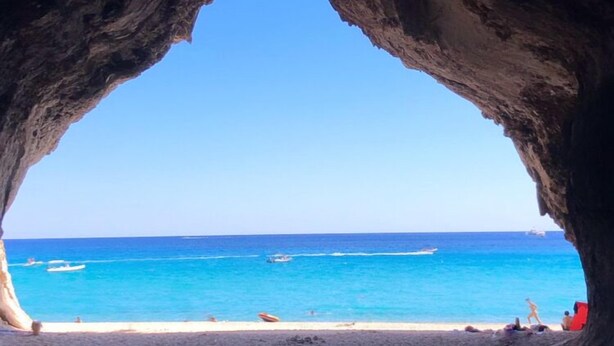 A beach with a clear view through a rock arch. - Apartment/ flat -Cala Gonone  - Casa dolce vista - Via delle Ginestre 20 (Cala Gonone)