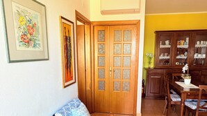 A living room with a sofa set, a dining table with chairs, and a kitchen area with cabinets. - Apartment/ flat -Cala Gonone  - Casa dolce vista - Via delle Ginestre 20 (Cala Gonone)