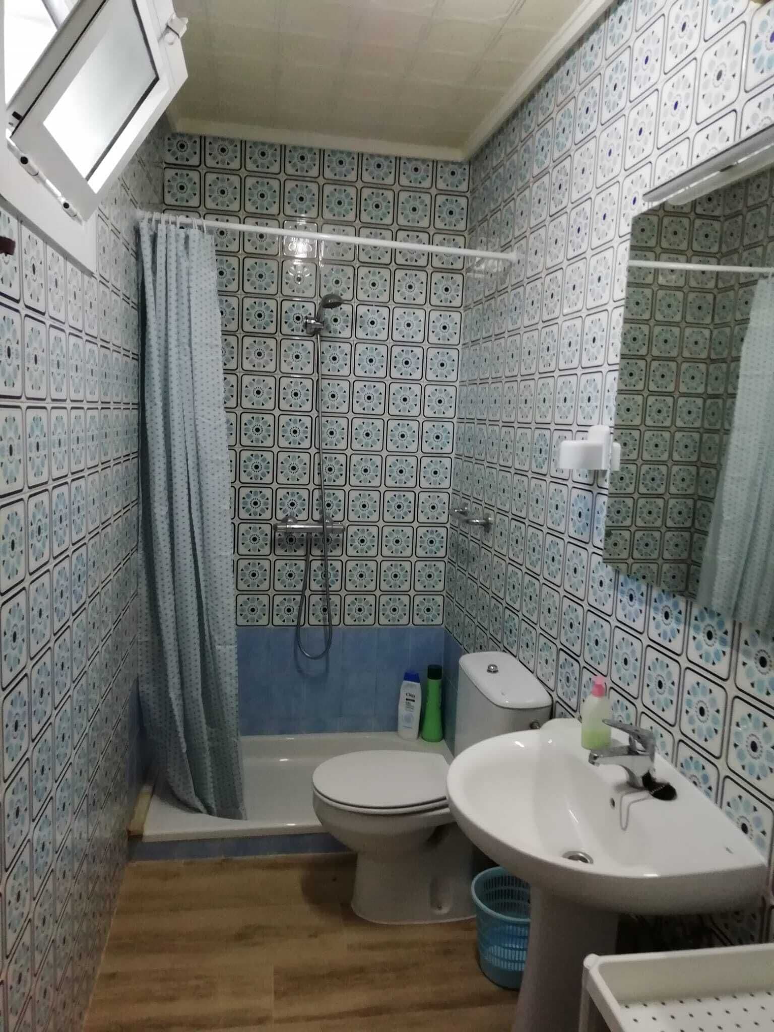 Un bagno con doccia, WC, lavandino e specchio.