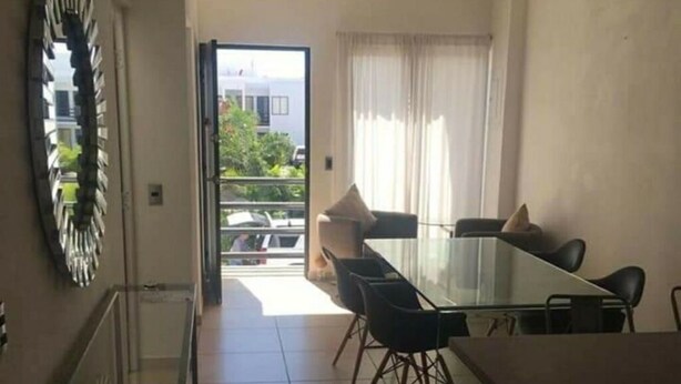 A dining area with a glass table and chairs, a ceiling fan, and a view of the outside balcony. - departamento duplex increible! (Fraccionamiento Las Ceibas)