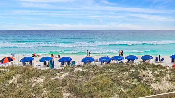 A beach with umbrellas and people. - Beach Front at Jetty East! One FREE Beach Chair Setup Each Day of Your Stay! (Destin)