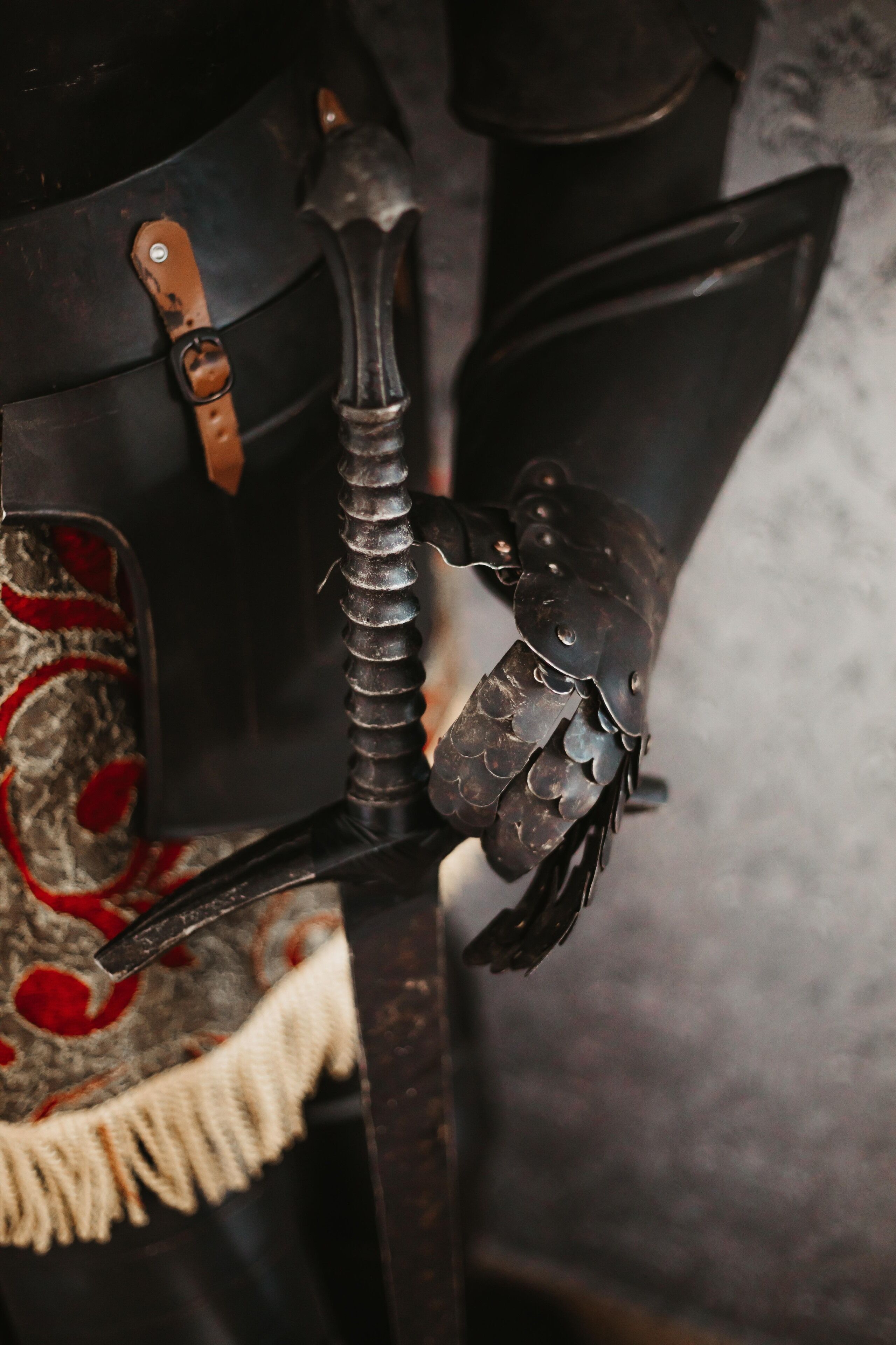A close-up of a medieval-style helmet with a leather strap and a decorative shield.