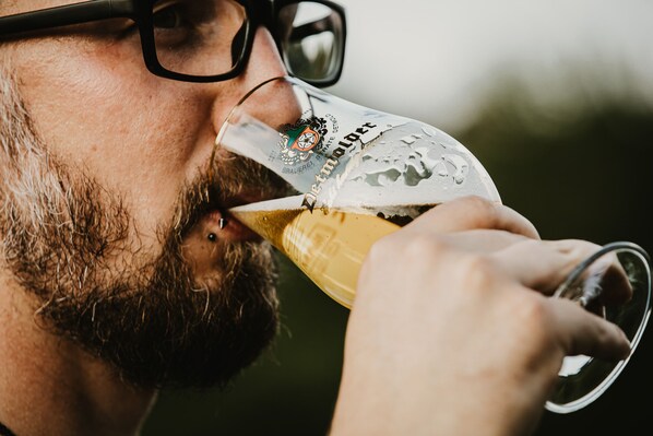 A close-up of a man drinking beer from a glass.
